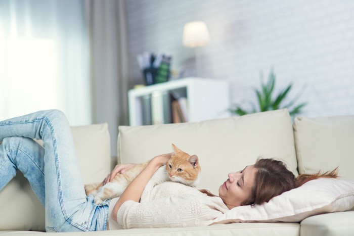 ソファーでくつろぐ女性と猫