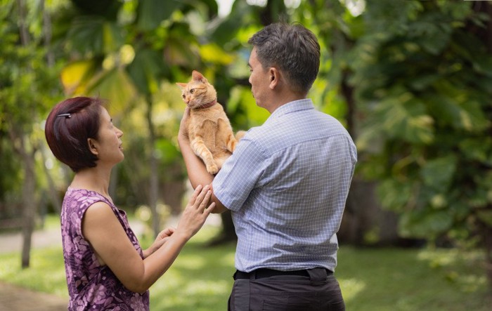 野外で猫と過ごす中年夫婦