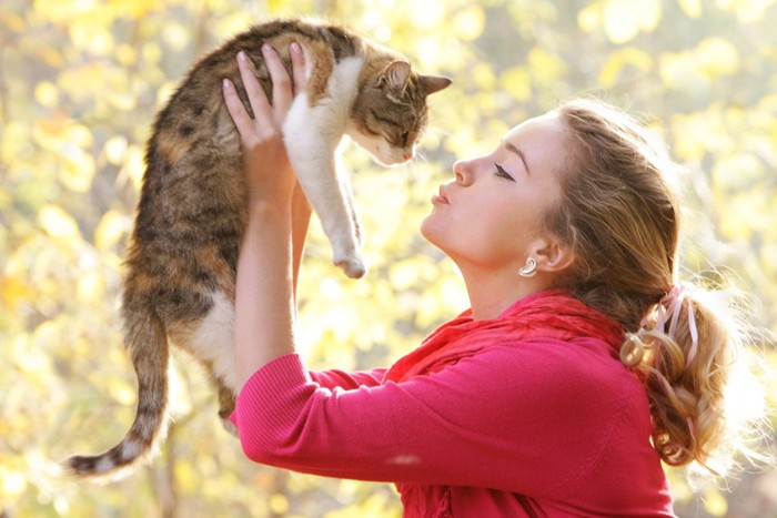 女性に抱かれる猫