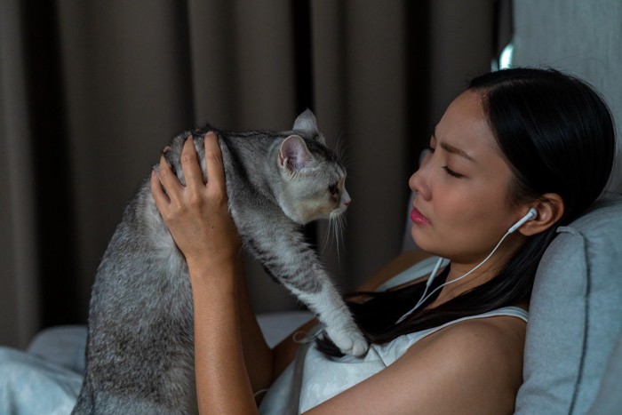 悲しそうな飼い主さんと猫