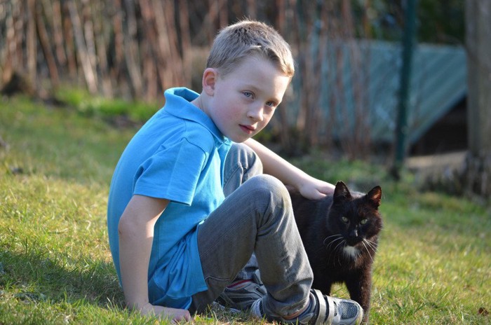 黒猫をなでる少年