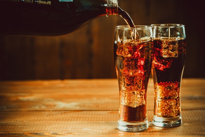 コップにコーラを注いでいる光景