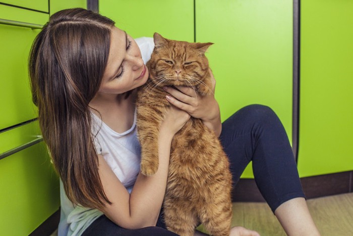 キッチンにいる女性と猫