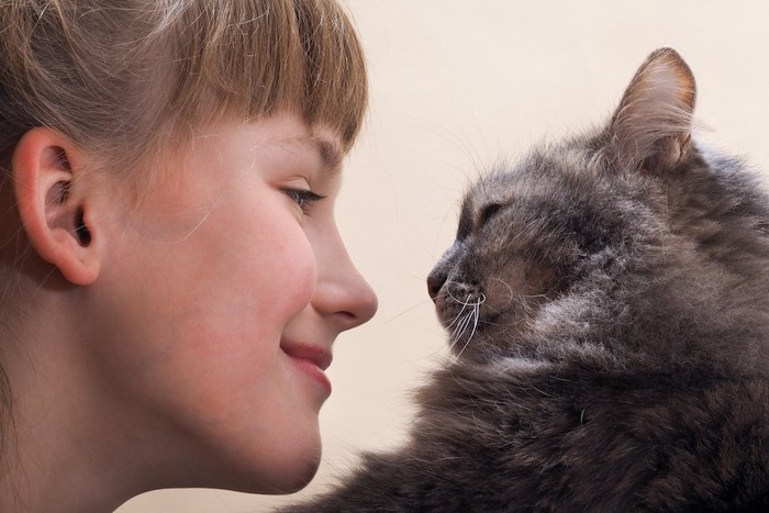 猫と見つめ合う笑顔の女性