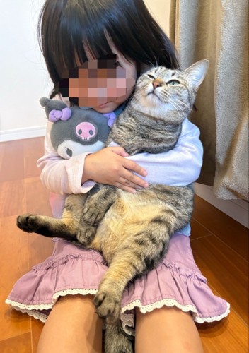 ぬいぐるみと猫を抱きしめる女の子