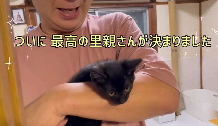 黒猫を抱っこする男性