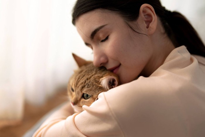 女性に抱っこされる猫