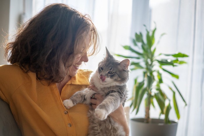 目を細めて猫を見つめる女性