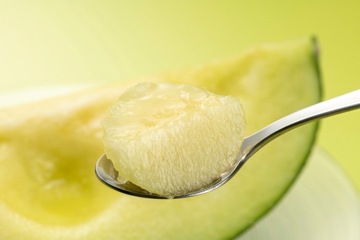 メロンの果肉をスプーンですくっている様子