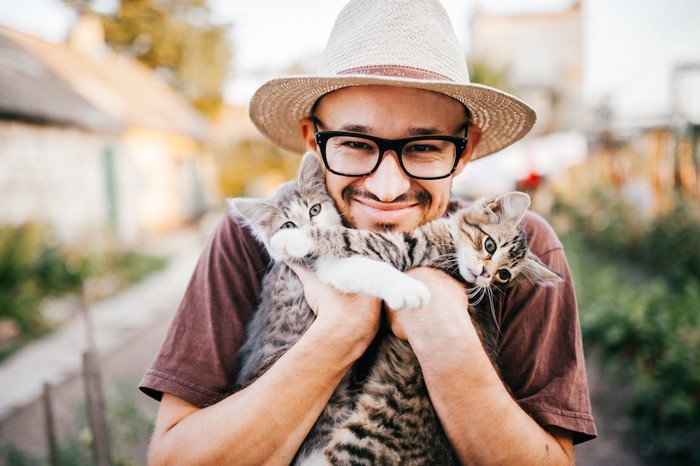 男性に抱かれる二匹の子猫