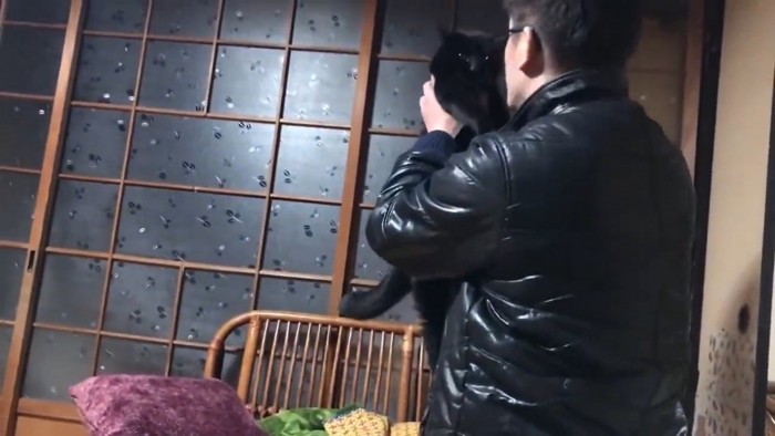 黒猫ちゃんを抱き上げるパパさん