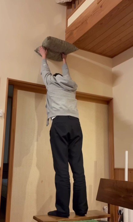 座布団を掲げる飼い主