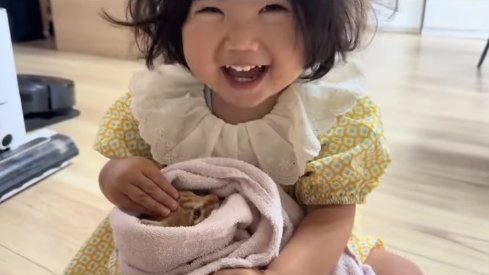 子猫を抱っこしながら笑っている子供(目線ズレ)