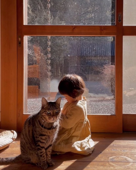 子ども前に座る猫