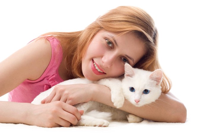 女性の腕にしがみつく猫