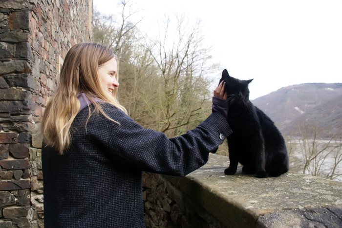黒猫を撫でる女性