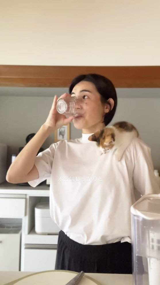 コップに入った水を飲む女性