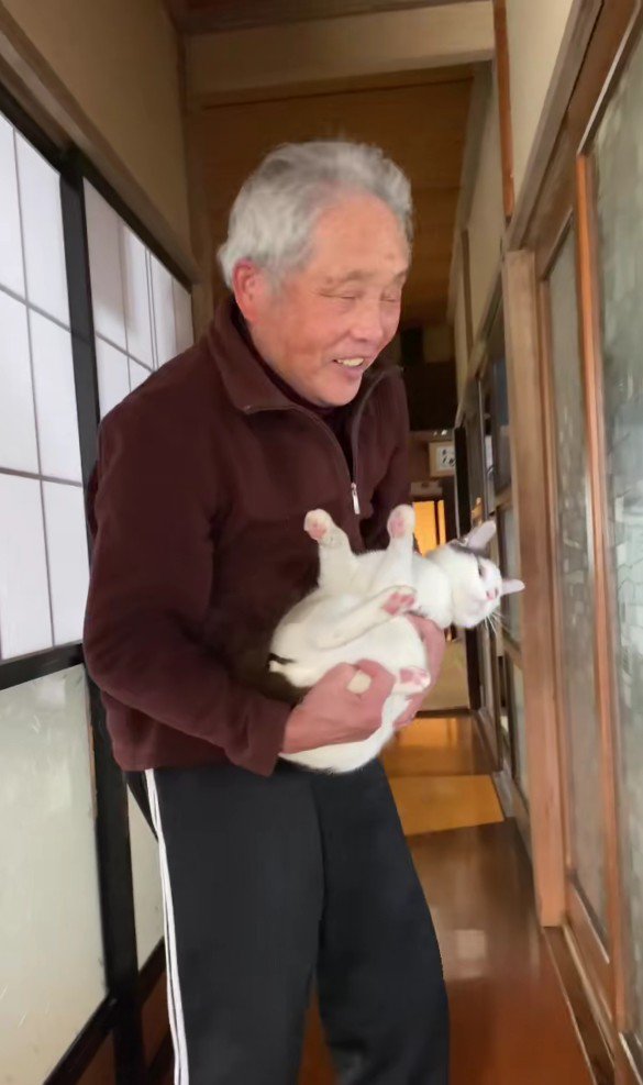 猫を抱っこするおじいちゃん