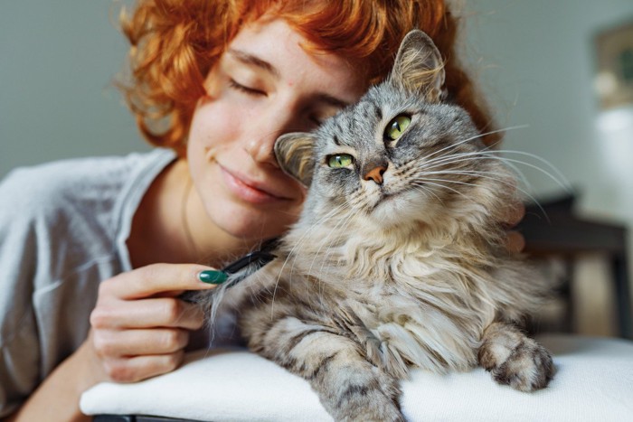 赤毛の女性と長毛猫