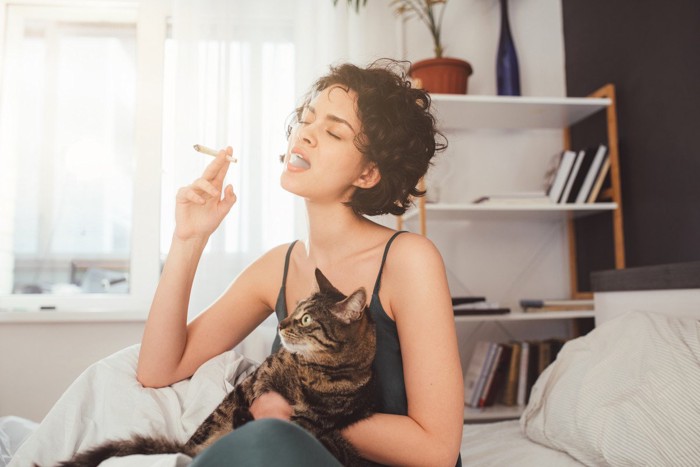 タバコを吸う女性と猫