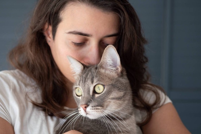 猫の匂いを嗅ぐ女性