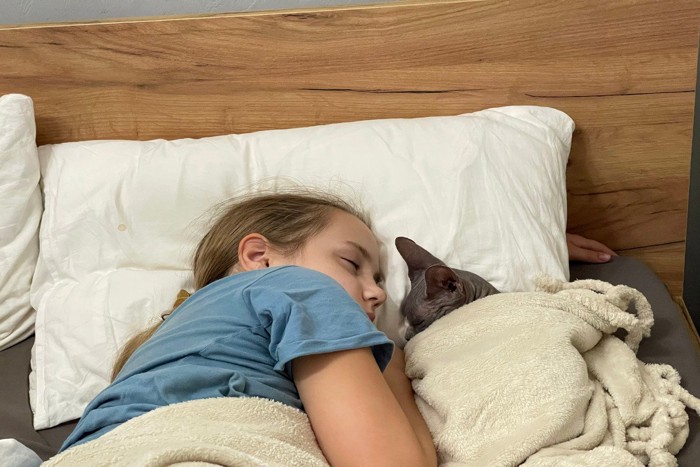 向き合いながら眠る少女と猫
