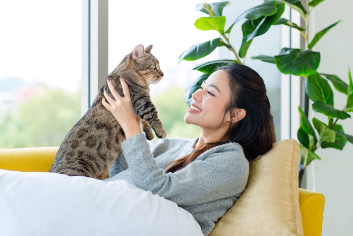 愛猫を抱きかかえる若い女性