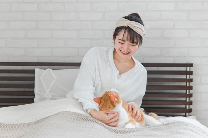 猫に笑顔で話しかける飼い主