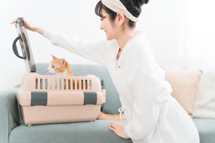 キャリーバッグに猫を入れる女性