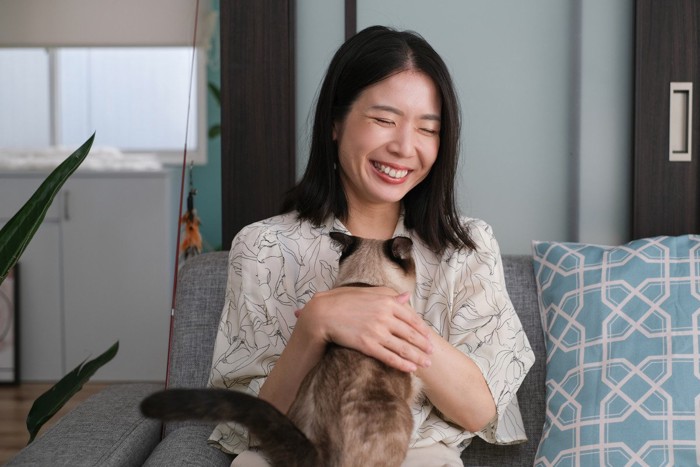 嬉しそうに猫を抱っこする女性