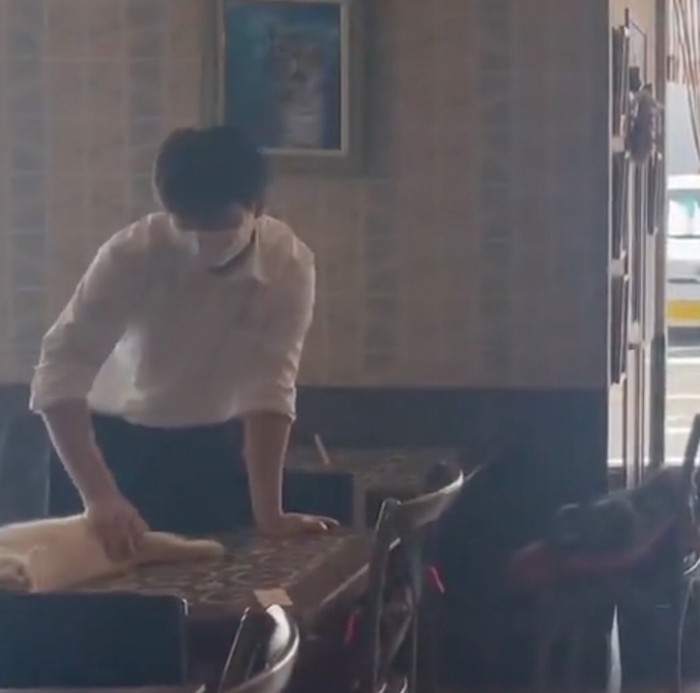 猫を撫でる手前の従業員