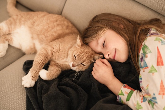 寝転がる猫と女の子