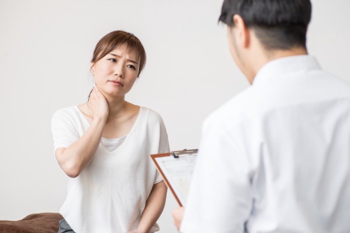 首に痛みを感じる女性