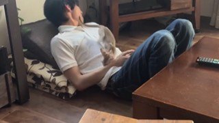 猫のしっぽに顔をそむける男性