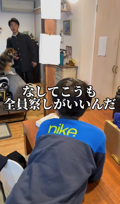 ソファの上にいる犬と画面手前にいる子供の方を見つめる制服の子供