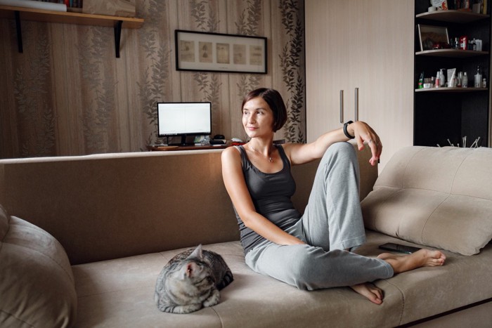 ソファーでくつろぐ女性と猫