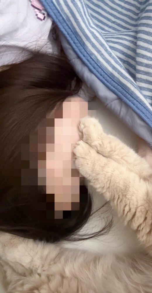 寝ている飼い主と猫の手