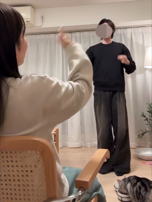 立っている人とごはんを食べる猫