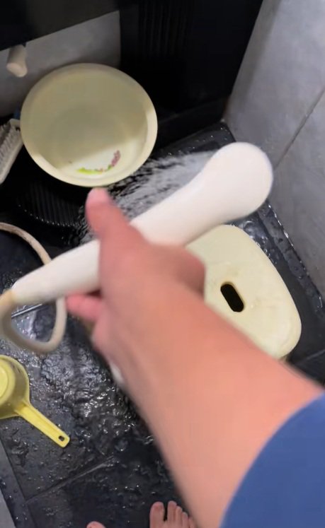 風呂場とシャワーを持つ手