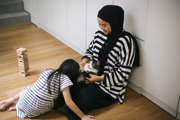 猫と遊ぶイスラムの母子