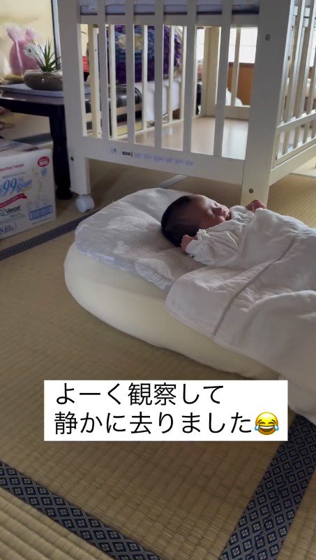 猫がいる方へ体を傾ける赤ちゃん