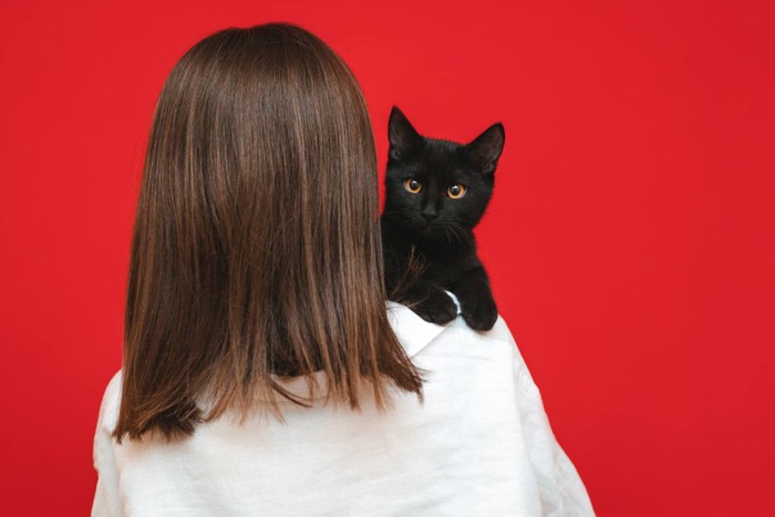 女性の肩に黒猫