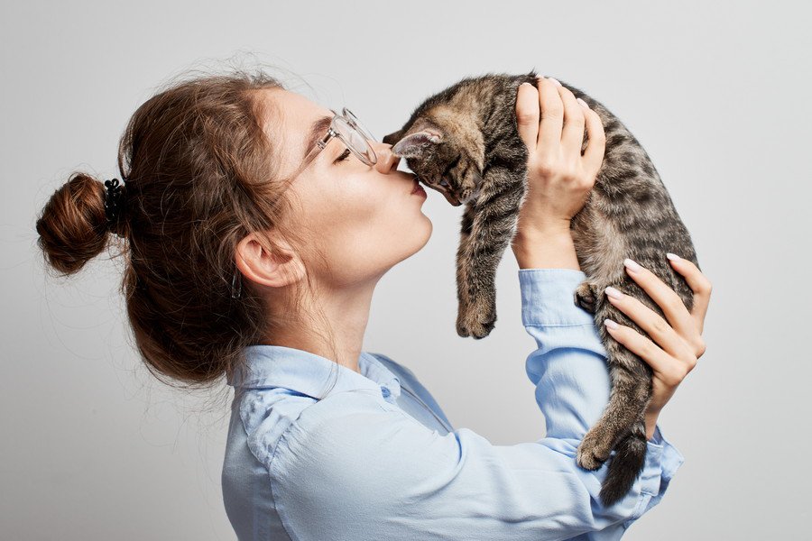 猫を抱き上げる女子学生