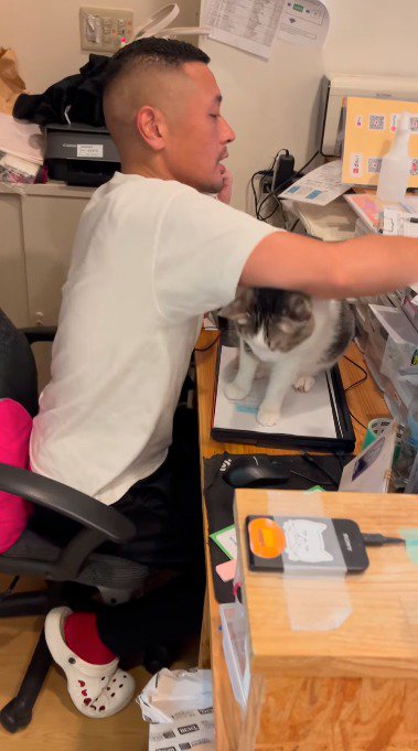 ノートを棚の上に置く男性