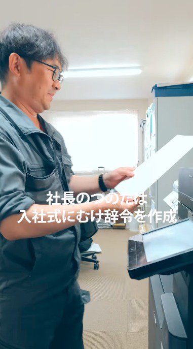 プリンターから出てきた紙を見つめる社長