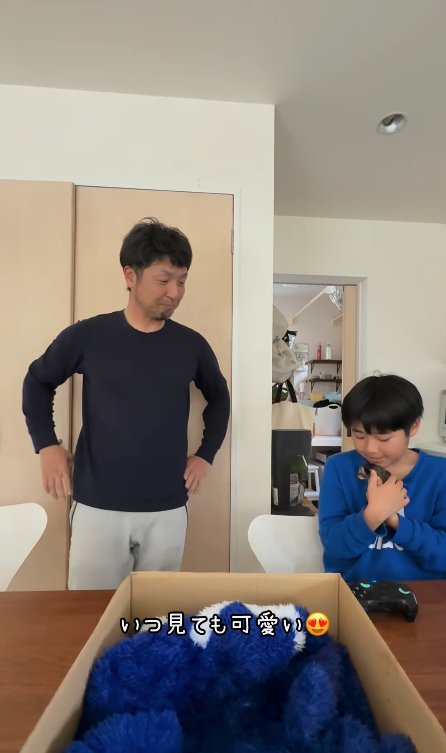 座って子猫を抱っこする子どもを見つめる男性