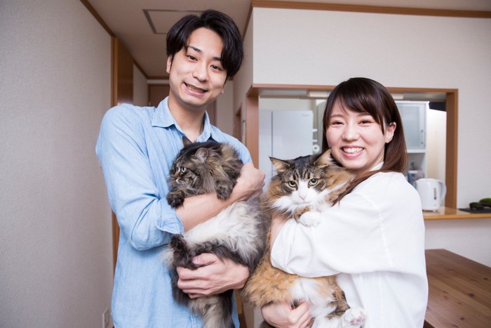 猫を抱きかかえる男女