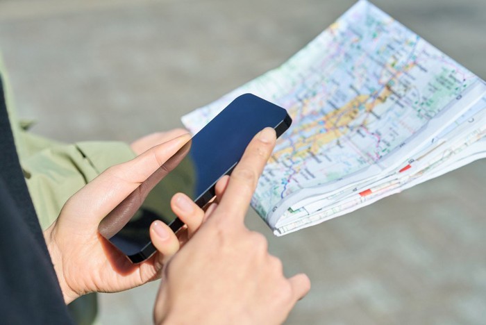 地図とスマホを持つ人