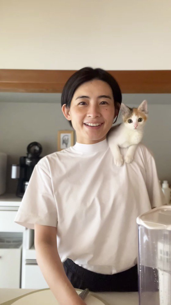 笑顔でカメラを見つめる女性と猫