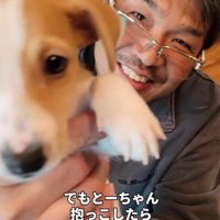 子犬を抱っこして笑顔を見せる男性